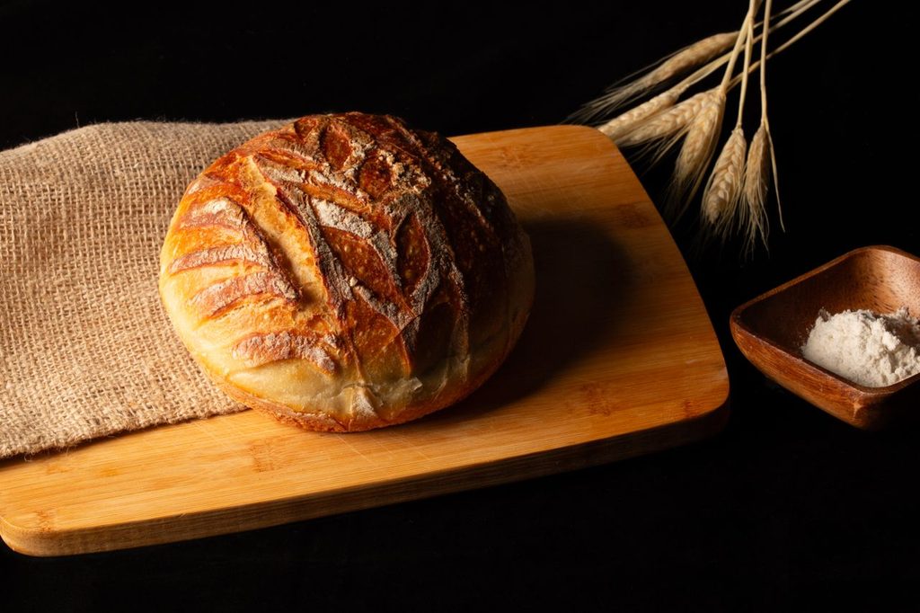 An attractive loaf of bread with a small bowl of salt