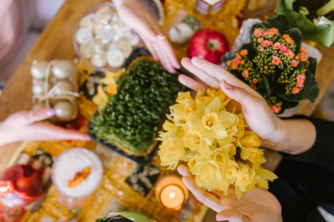 12 Thoughtful Nowruz Gift Ideas for Persian New Year 2 A colourful Nowruz gift arrangement beside a Haft-Seen table
