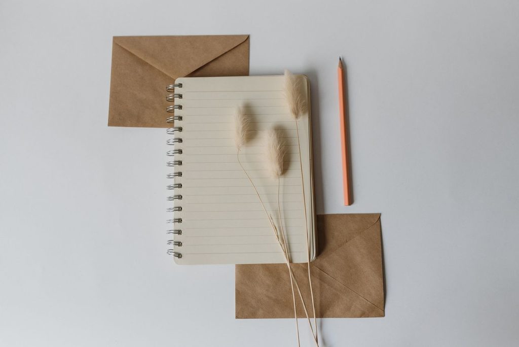 10 Respectful Gift Ideas for Japanese Hosts & Host Families 4 Notebook with brown envelopes and pencil on white background