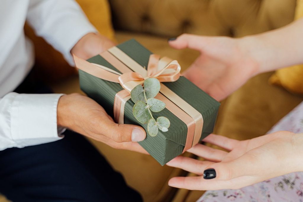 10 Respectful Gift Ideas for Japanese Hosts & Host Families 5 Wrapped gift being presented with both hands to a Japanese host